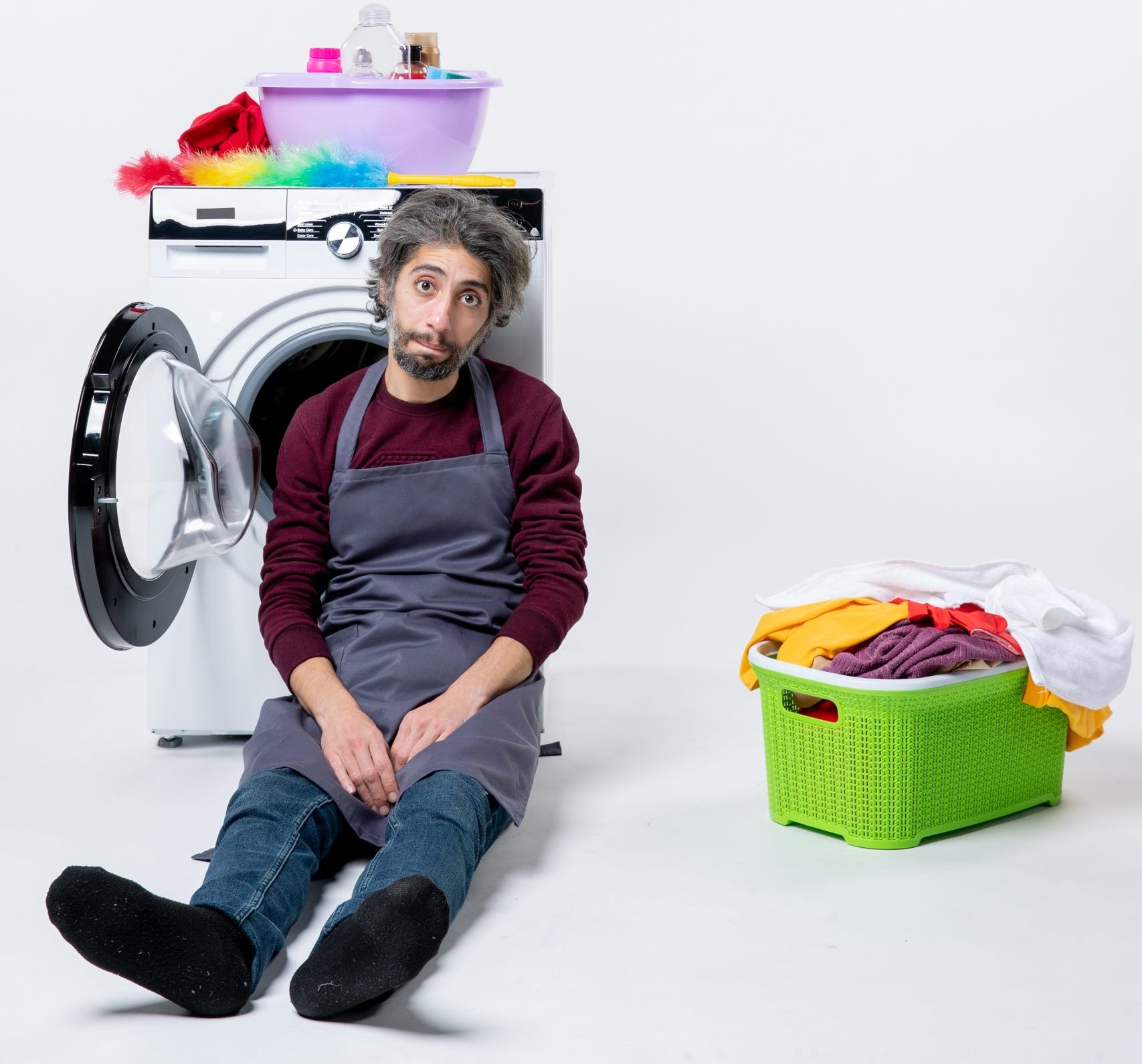front-view-dispirited-housekeeper-man-sitting-near-laundry-basket-white-background